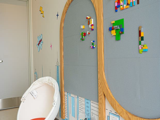 Baño infantil del consultorio con un muro de piezas de construcción para jugar.